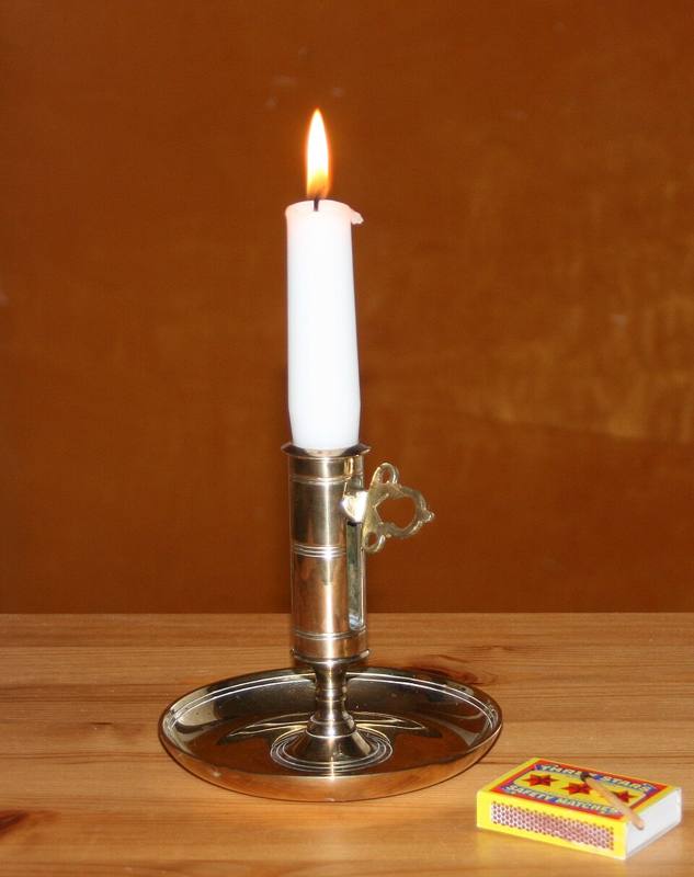 Lit candle with a melted wax pool